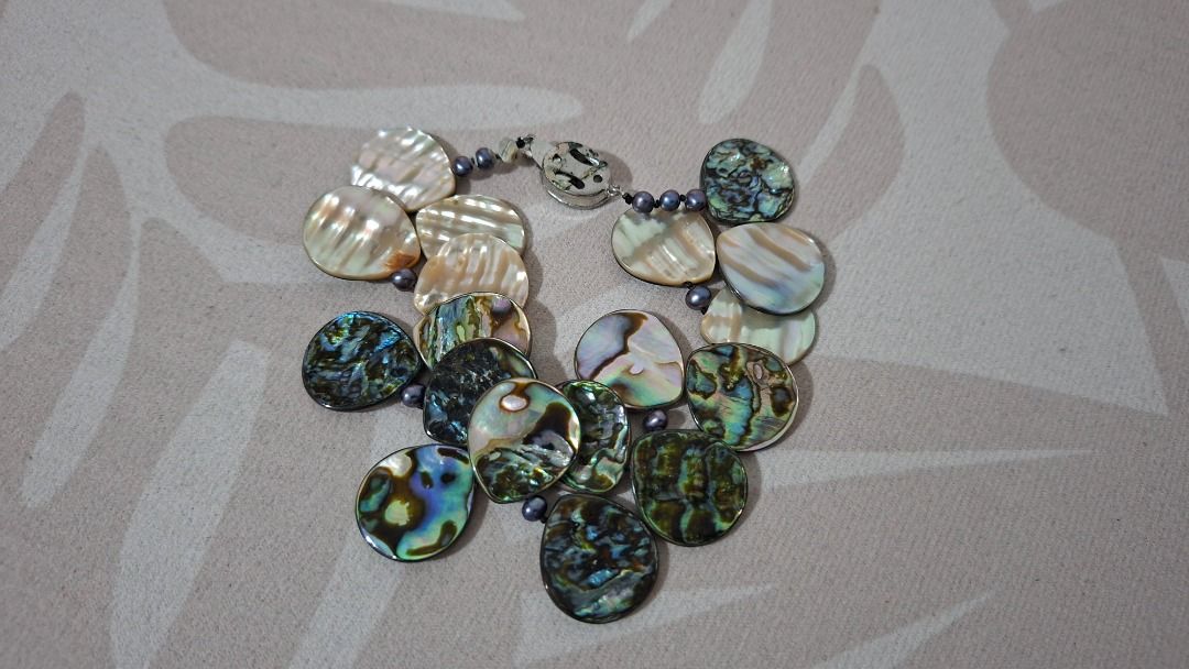 Abalone Shell Bracelet (Category: Bracelets) located in Imus. Submitted by pick_and_dig (Listing ID 1426206691, Image 3). Description: Beautiful bracelet features iridescent abalone shell pieces. The bracelet is strung together with small, dark beads and has a silver-colored clasp. The abalone shells display a range of colors, including blues, greens, and creams. It's a unique accessory that would complement any outfit. MOP: GCash, Maya.