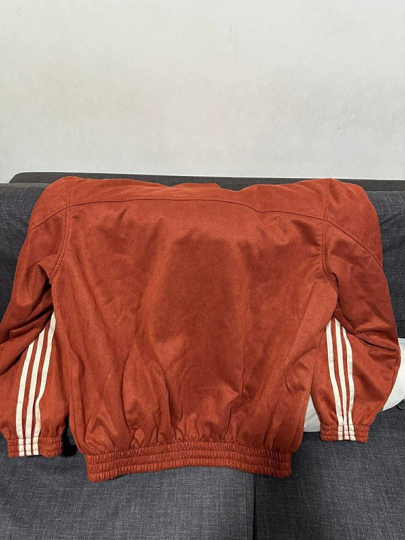 Adidas Track Jacket with Chinese Knot Buttons (Category: Coats, Jackets and Outerwear) located in Manila. Submitted by ukaygandamo (Listing ID 1426199350, Image 3). Description: Adidas track jacket features a unique design with Chinese knot buttons. It has the classic Adidas three stripes on the sleeves and the Adidas logo on the chest. The jacket has a mandarin collar and a zipper closure. The color is a reddish-orange. The jacket has a ribbed h