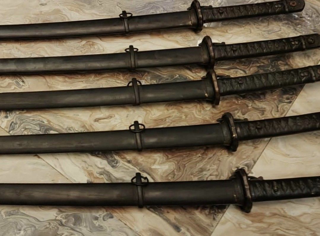 Antique Katana Swords (Category: Vintage Collectibles) located in Manila. Submitted by npjnqmart (Listing ID 1426292151, Image 1). Description: Set of antique katana swords. Each sword features a dark scabbard and intricately detailed hilt. The blades are sheathed, and the overall appearance suggests a vintage or antique origin. The swords are displayed on a patterned surface, showcasing their design and craftsmanship..