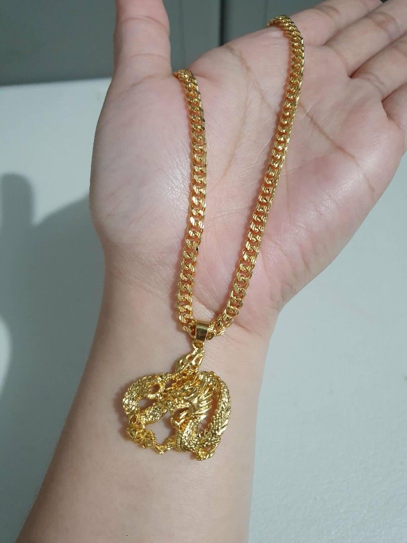 Gold tone Dragon Pendant Necklace (Category: Necklaces) located in Las Pinas. Submitted by broeater (Listing ID 1426336374, Image 3). Description: Gold tone necklace features a detailed dragon pendant. The chain has a thick, cuban link design. The pendant showcases a dragon with intricate scales and features. It's a bold and eye-catching piece, perfect for adding a touch of style to any outfit..