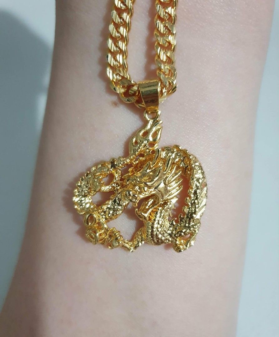 Gold tone Dragon Pendant Necklace (Category: Necklaces) located in Las Pinas. Submitted by broeater (Listing ID 1426336374, Image 2). Description: Gold tone necklace features a detailed dragon pendant. The chain has a thick, cuban link design. The pendant showcases a dragon with intricate scales and features. It's a bold and eye-catching piece, perfect for adding a touch of style to any outfit..