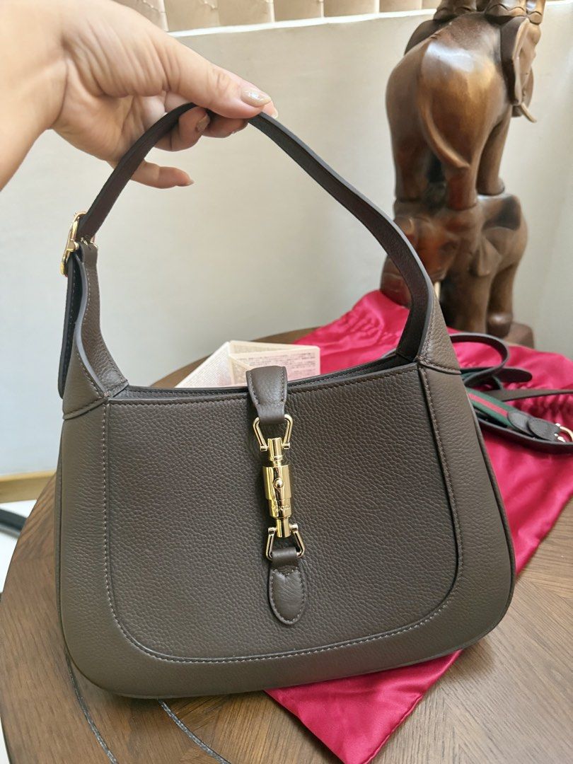 Gucci Jackie 1961 Small Shoulder Bag (Category: Luxury Bags & Wallets) located in Quezon City. Submitted by lavieluxe08 (Listing ID 1426299819, Image 1). Description: Gucci Jackie 1961 shoulder bag features a brown leather exterior with a gold-tone clasp. It includes a detachable shoulder strap with green and red stripes. The interior has a zippered pocket and a fabric lining. Comes with a dust bag and authenticity cards. Made in Italy..