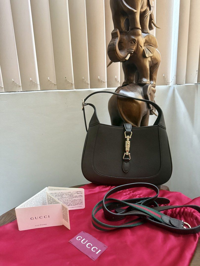 Gucci Jackie 1961 Small Shoulder Bag (Category: Luxury Bags & Wallets) located in Quezon City. Submitted by lavieluxe08 (Listing ID 1426299819, Image 2). Description: Gucci Jackie 1961 shoulder bag features a brown leather exterior with a gold-tone clasp. It includes a detachable shoulder strap with green and red stripes. The interior has a zippered pocket and a fabric lining. Comes with a dust bag and authenticity cards. Made in Italy..