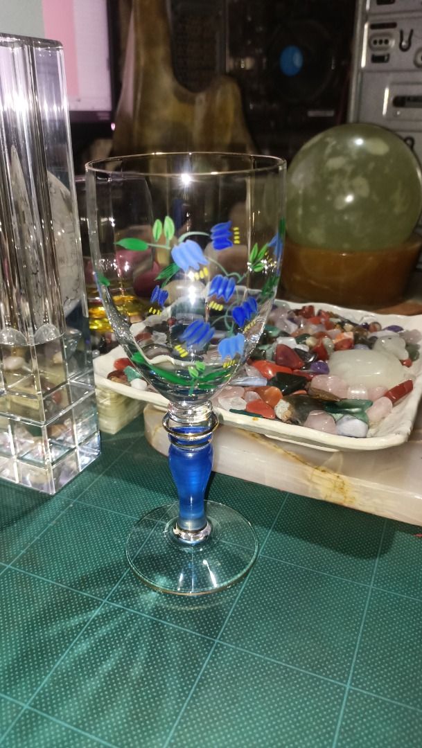 Hand-Painted Floral Wine Glasses (Category: Dinnerware & Cutlery) located in Munoz. Submitted by larryc1212 (Listing ID 1426225530, Image 3). Description: Set of two elegant wine glasses featuring hand-painted blue floral designs. Each glass has a blue stem with gold accents. The glasses are approximately 7 inches tall. Perfect for serving wine or as a decorative piece. The glasses have a clear bowl and a delicate, detailed design. Item may inclu