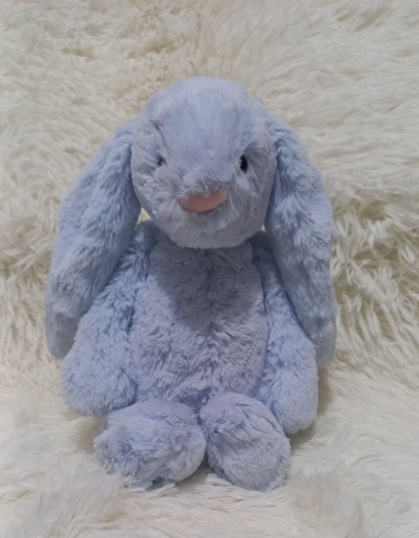 Jellycat Bashful Blue Bunny( available 2pcs)(Medium) (Category: Plushies & Soft Toys) located in Taguig. Submitted by phlercollections (Listing ID 1426226533, Image 1). Description: Adorable Jellycat Bashful Bunny is a soft and cuddly plush toy. It features long, floppy ears and a sweet pink nose. The bunny is a light blue color and has a fluffy texture. Perfect for snuggling or as a decorative piece in a nursery or bedroom..