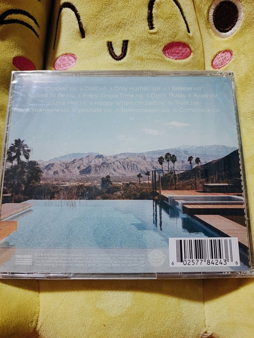 Jonas Brothers Happiness Begins CD (Category: CDs & DVDs) located in Caloocan City. Submitted by deleonmaik02060 (Listing ID 1426242817, Image 2). Description: CD of the Jonas Brothers' album "Happiness Begins." It includes the song "Sucker." The CD is still sealed in its original packaging. The back of the CD case shows the tracklist, including songs like "Cool," "Only Human," and "I Believe.".