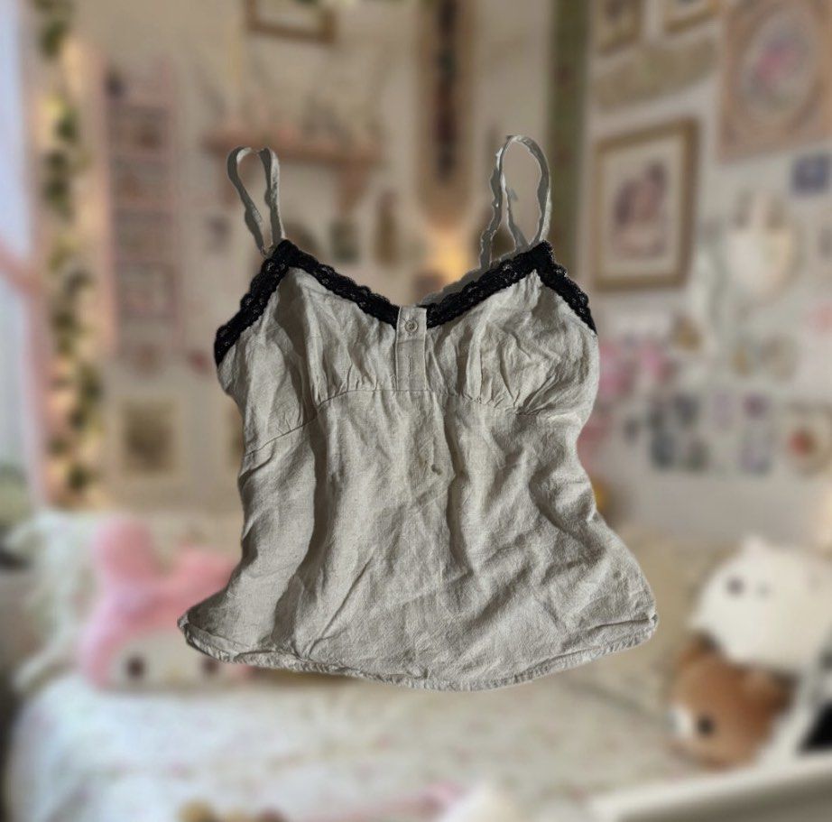 Linen Camisole with Lace Trim (Category: Sleeveless) located in Manila. Submitted by sofiaax (Listing ID 1426197734, Image 1). Description: -cream-colored top with lace trim -condition: has a little stain in the middle (washable) payment: gcash onlyy delivery: J&T or lalamove :) tags: alt fairycore clean girl pinterest lace boho y2k 2000s dainty chic brandy melville hollister layering .