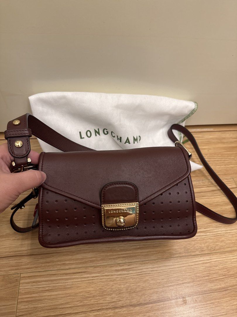 Longchamp Leather Crossbody Bag (Category: Luxury Bags & Wallets) located in Consolacion. Submitted by jesfats (Listing ID 1426324034, Image 1). Description: Elegant Longchamp crossbody bag in a rich burgundy color. Features a gold-tone clasp and perforated detailing on the front. Includes a dust bag. The bag has a long strap for shoulder or crossbody wear. Perfect for everyday use or special occasions..