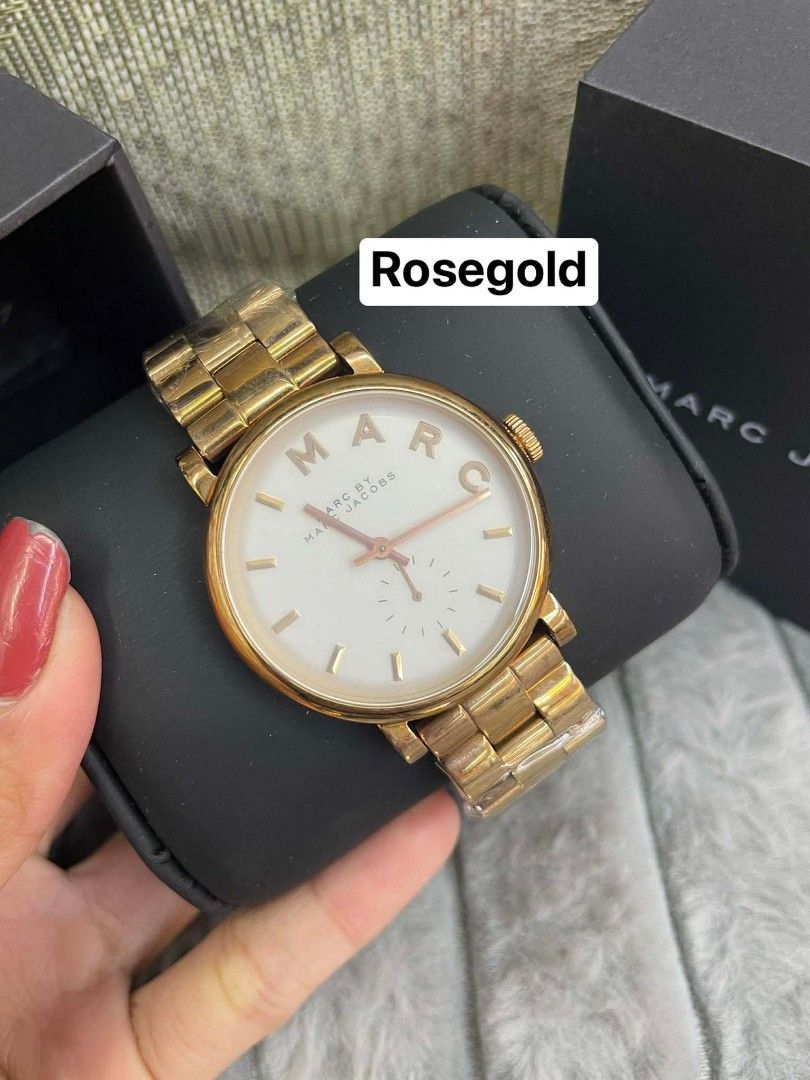 Marc Jacobs Rosegold Watch (Category: Women's Watches) located in Bulacan. Submitted by yukionnana (Listing ID 1426262444, Image 1). Description: ‼️SALE‼️SALE‼️ SALE‼️ 2,950 w/Box ( size 38’mm)+ SF Marc Jacobs watch features a rosegold finish. The watch has a white dial with rosegold hands and markers. The watch comes with its original box. The band is made of metal and has a clasp closure. The watch is a stylish accessory for everyday wear..