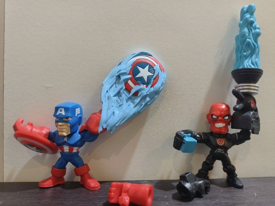 Marvel Super Hero Squad Figures (Category: Figurines & Statues) located in Baguio. Submitted by alk08 (Listing ID 1426286476, Image 2). Description: Listing includes two Marvel Super Hero Squad figures: Captain America and Red Skull. Captain America has a shield and a blue energy effect. Red Skull has a torch-like accessory. Both figures are in a stylized, cartoonish design. The figures appear to be made of plastic and are suitable for display or