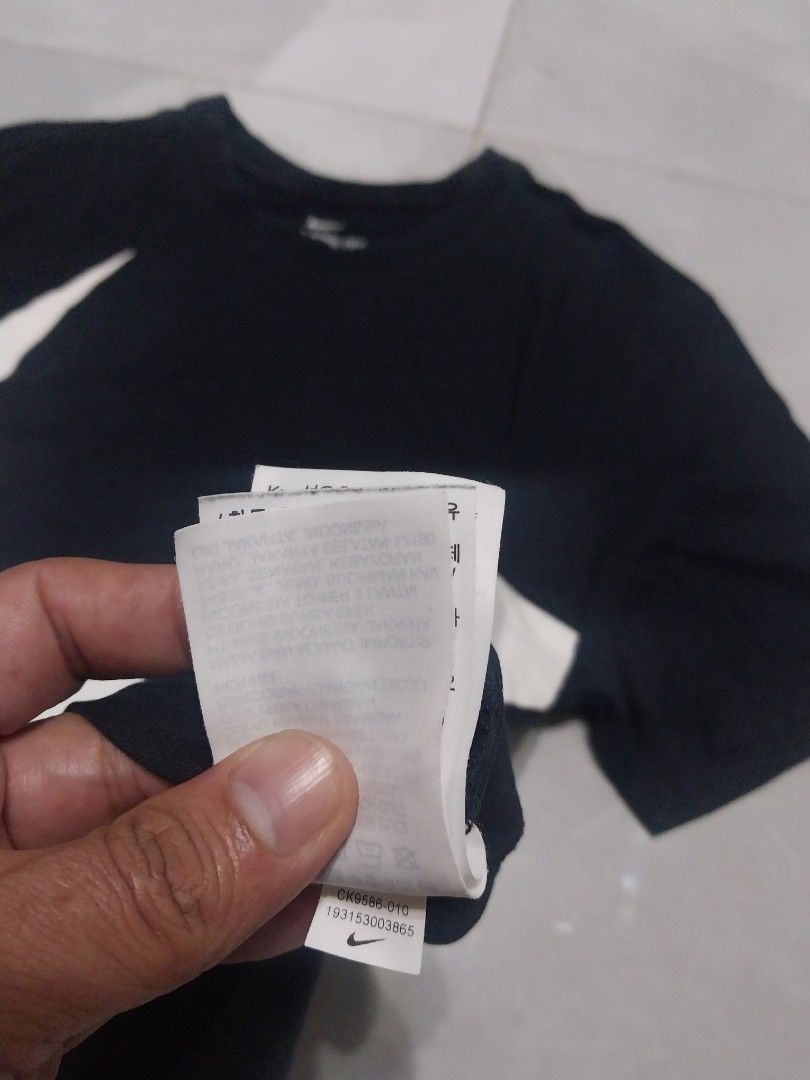 Nike Tee with Large Swoosh (Category: Tshirts & Polo Shirts ) located in Malaybalay. Submitted by markdaumar08466 (Listing ID 1426304178, Image 2). Description: Black Nike T-shirt featuring a large white Swoosh logo. The shirt has a crew neck and short sleeves. The tag indicates it is a Nike Tee. The size is indicated on the tag. Made in China..