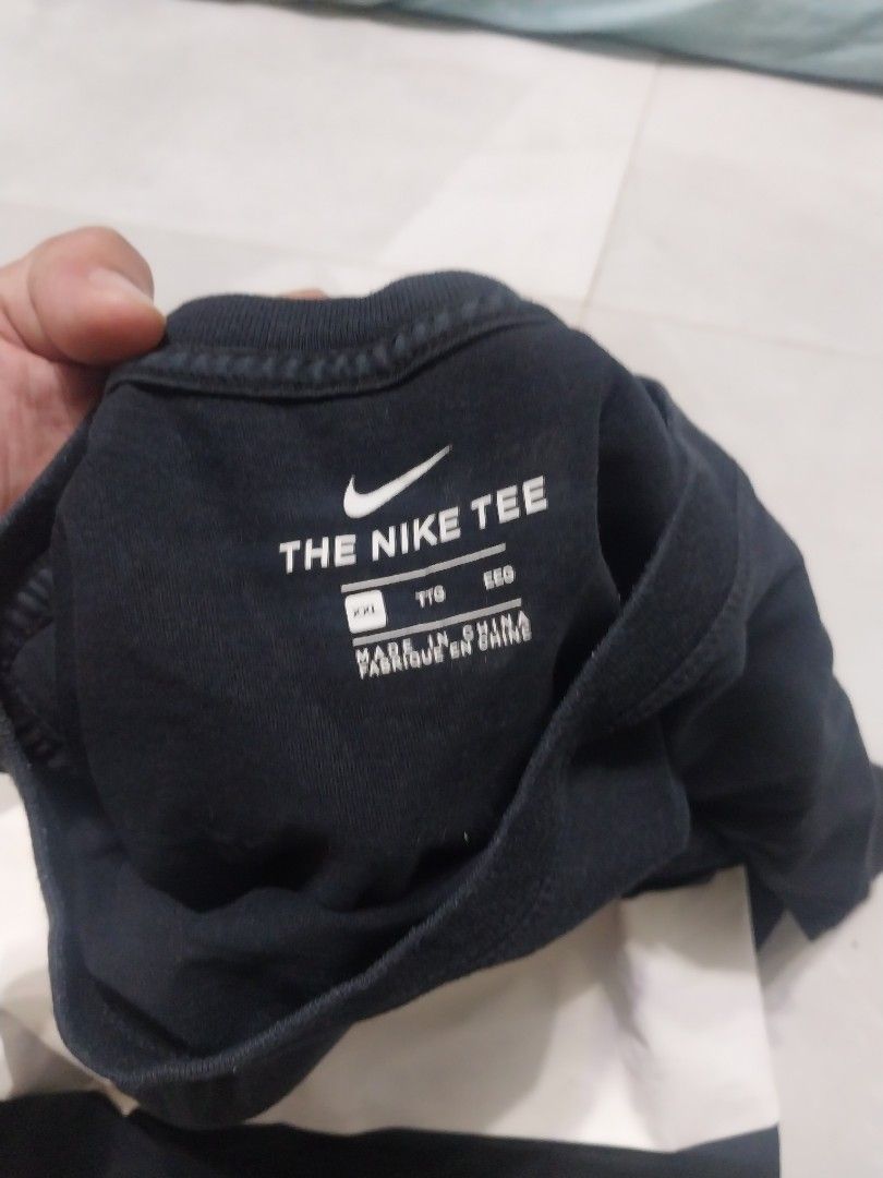 Nike Tee with Large Swoosh (Category: Tshirts & Polo Shirts ) located in Malaybalay. Submitted by markdaumar08466 (Listing ID 1426304178, Image 3). Description: Black Nike T-shirt featuring a large white Swoosh logo. The shirt has a crew neck and short sleeves. The tag indicates it is a Nike Tee. The size is indicated on the tag. Made in China..