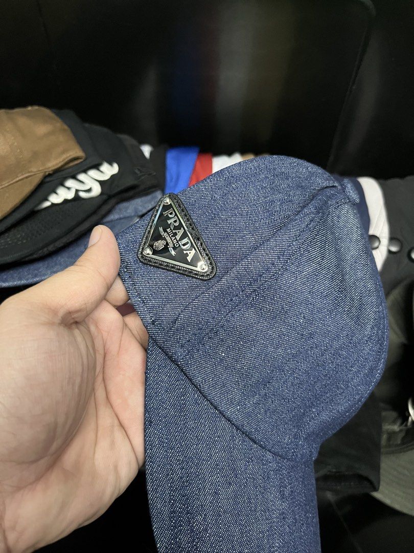Prada Denim Cap (Category: Caps & Hats) located in Quezon City. Submitted by headline. (Listing ID 1426355446, Image 2). Description: Prada cap in denim. Features the iconic Prada triangle logo on the Side. The interior label indicates "Prada - Milano" and the material composition: 100% cotton for the outer and 100% polyester for the lining. FITS TO ALL EXCELLENT CONDITION FOR ONLY:1,300php +SHIPPING FEE.