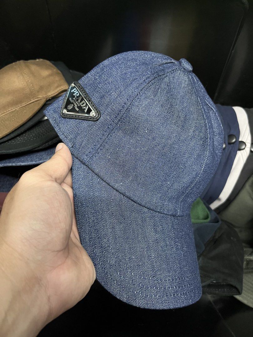 Prada Denim Cap (Category: Caps & Hats) located in Quezon City. Submitted by headline. (Listing ID 1426355446, Image 1). Description: Prada cap in denim. Features the iconic Prada triangle logo on the Side. The interior label indicates "Prada - Milano" and the material composition: 100% cotton for the outer and 100% polyester for the lining. FITS TO ALL EXCELLENT CONDITION FOR ONLY:1,300php +SHIPPING FEE.