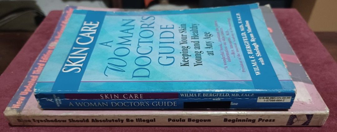Skin Care and Makeup Books (Category: Makeup) located in Quezon City. Submitted by wjmae (Listing ID 1426303113, Image 3). Description: Two books on skin care and makeup. One is "Blue Eyeshadow Should Be Illegal" by Paula Begoun, and the other is "Skin Care: A Woman Doctor's Guide" by Wilma F. Bergfeld. Both books offer advice on skin care and makeup application. The books are in English..