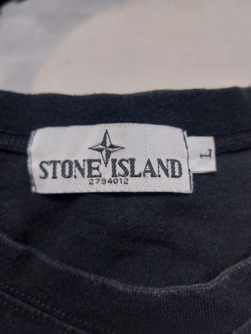 Stone Island Black T-shirt (Category: Tshirts & Polo Shirts ) located in Malaybalay. Submitted by markdaumar08466 (Listing ID 1426215747, Image 3). Description: Black Stone Island T-shirt with a large white logo on the back. The front features a graphic design with the Stone Island logo. The size tag indicates a size L. Made of a comfortable fabric, perfect for casual wear. A stylish addition to any wardrobe..