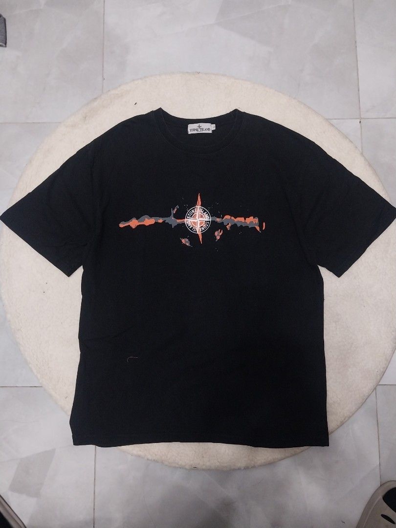 Stone Island Black T-shirt (Category: Tshirts & Polo Shirts ) located in Malaybalay. Submitted by markdaumar08466 (Listing ID 1426215747, Image 2). Description: Black Stone Island T-shirt with a large white logo on the back. The front features a graphic design with the Stone Island logo. The size tag indicates a size L. Made of a comfortable fabric, perfect for casual wear. A stylish addition to any wardrobe..