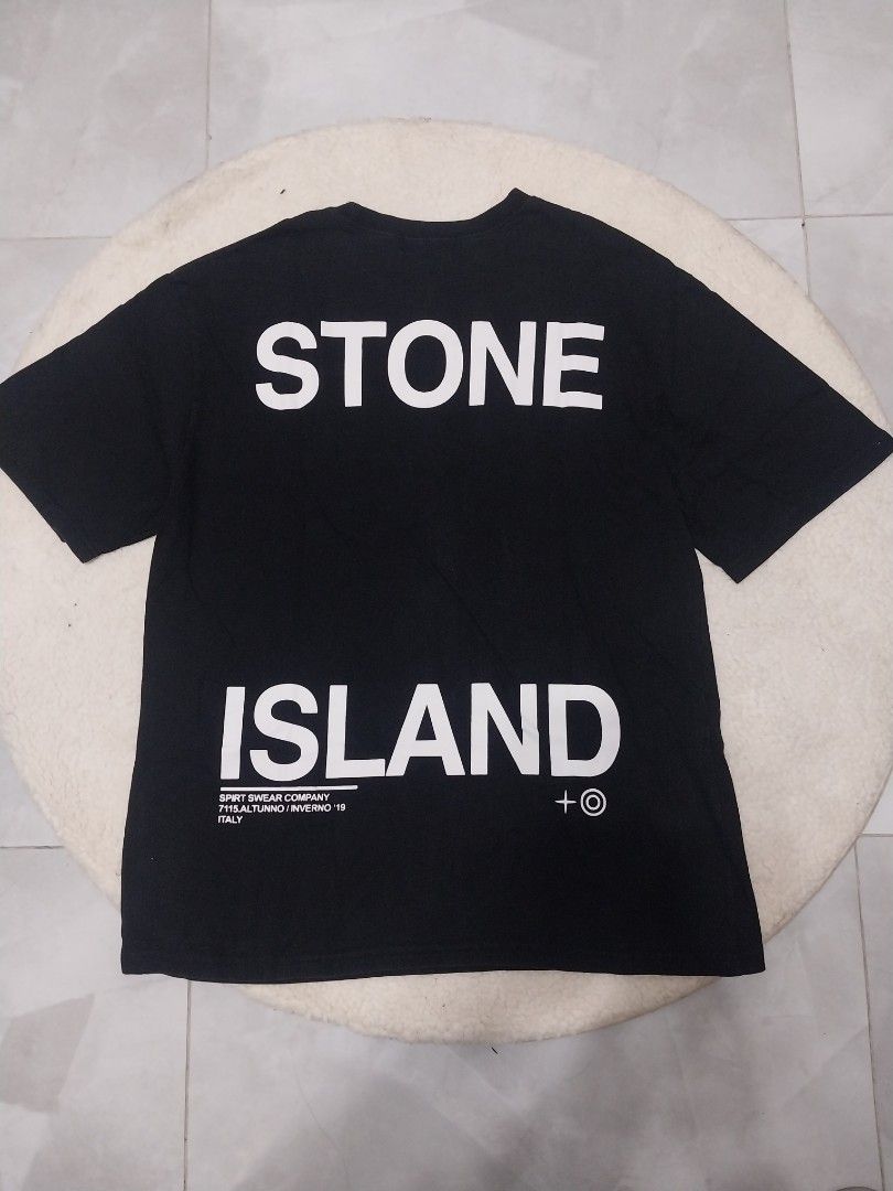 Stone Island Black T-shirt (Category: Tshirts & Polo Shirts ) located in Malaybalay. Submitted by markdaumar08466 (Listing ID 1426215747, Image 1). Description: Black Stone Island T-shirt with a large white logo on the back. The front features a graphic design with the Stone Island logo. The size tag indicates a size L. Made of a comfortable fabric, perfect for casual wear. A stylish addition to any wardrobe..