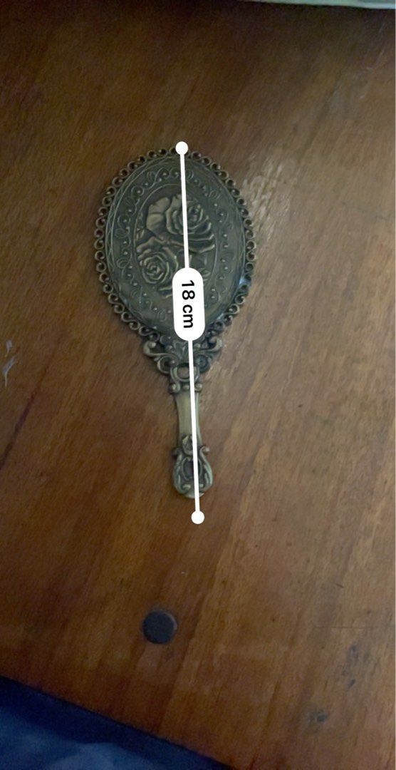 Vintage Oval Hand Mirror with Rose Design (Category: Mirrors) located in Cavite. Submitted by msandysgoodies (Listing ID 1426227938, Image 3). Description: Elegant vintage hand mirror with an oval shape. Features a decorative frame and handle with a rose design on the back. The mirror measures 18 cm in length and 8 cm in width. The handle has a decorative design at the end. The mirror is made of metal with a bronze color..