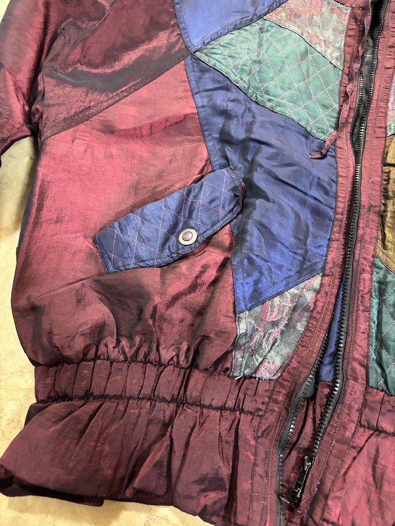 Vintage Patchwork Jacket (Category: Coats, Jackets and Outerwear) located in Alicia. Submitted by rangelenem23336 (Listing ID 1426297648, Image 2). Description: Vintage jacket features a unique patchwork design with various colors and textures. It has a zip-up front, two pockets, and elastic cuffs and hem. The jacket has a quilted lining for added warmth. It is a stylish and eye-catching piece perfect for adding a pop of color to any outfit. 📏sh