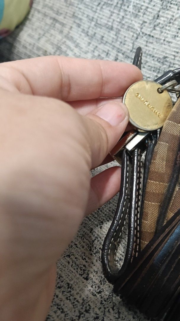 Authentic Givenchy Keyring sling bag (Category: Luxury Bags & Wallets) located in Calapan. Submitted by samsalazar68244 (Listing ID 1426533315, Image 1). Description: Givenchy keyring with a gold-tone circular tag. The tag has the brand name engraved on it. The keyring has a black leather strap and a brown and beige patterned fabric..