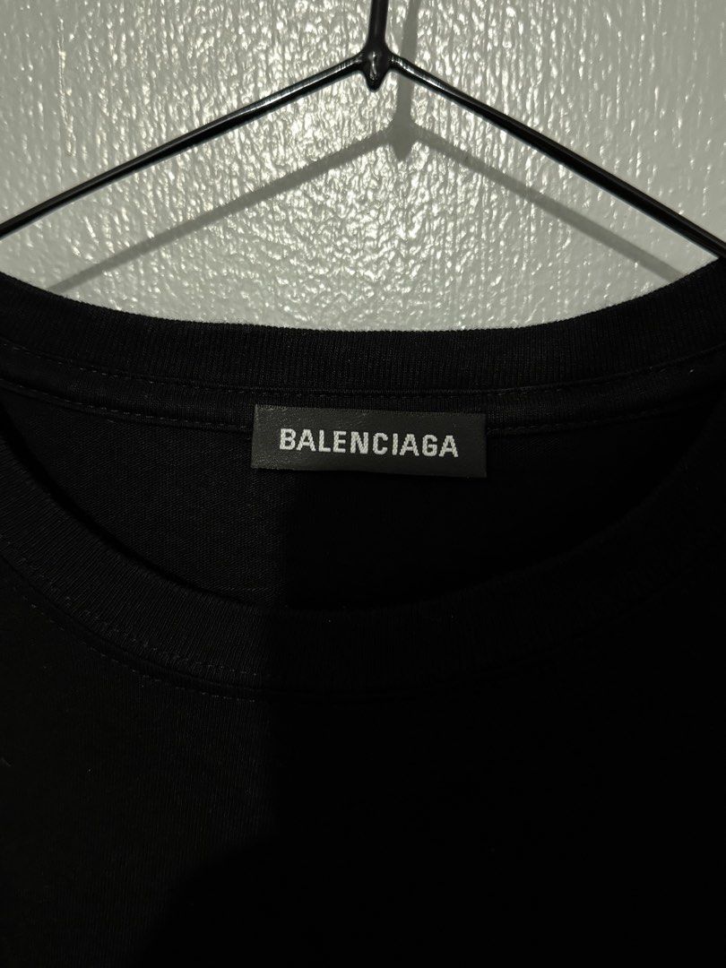 Balenciaga Black T-shirt (Authentic) (Category: Luxury Apparel) located in Bulacan. Submitted by hilligna (Listing ID 1426505374, Image 3). Description: Authentic Balenciaga black t-shirt. Features the Balenciaga logo on the neck and tag. Made in Portugal. Size M. The t-shirt has a classic crew neck and short sleeves. It is a versatile piece that can be dressed up or down. Perfect for everyday wear. Brandnew Condition Size M can Fit to Large.
