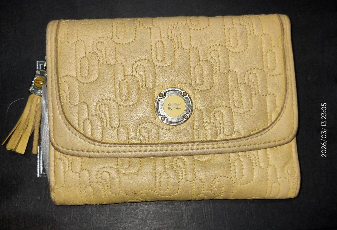 Banabana Yellow Wallet (Category: Wallets & Card holders) located in Los Banos. Submitted by tritrollse.04 (Listing ID 1426487665, Image 1). Description: Yellow Banabana wallet with a flap closure. Features a stitched pattern on the exterior. Includes multiple card slots, a clear ID window, and a zippered compartment. The wallet has a tassel detail and a metal logo. The interior is a lighter shade of yellow..