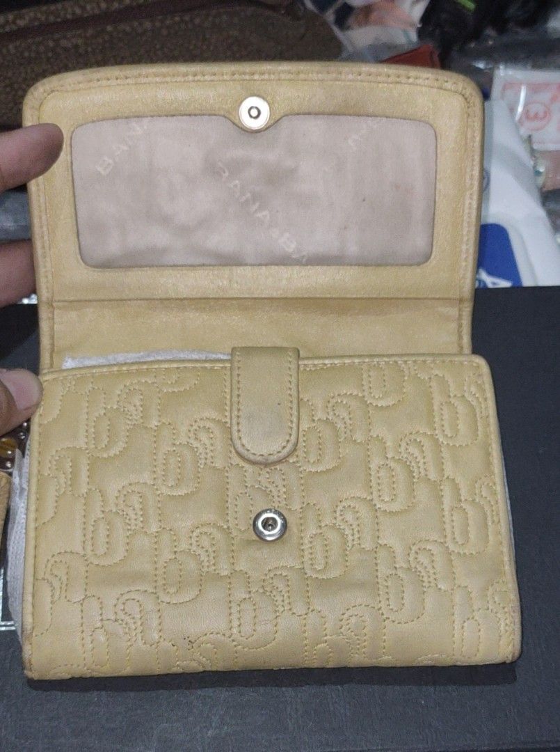 Banabana Yellow Wallet (Category: Wallets & Card holders) located in Los Banos. Submitted by tritrollse.04 (Listing ID 1426487665, Image 2). Description: Yellow Banabana wallet with a flap closure. Features a stitched pattern on the exterior. Includes multiple card slots, a clear ID window, and a zippered compartment. The wallet has a tassel detail and a metal logo. The interior is a lighter shade of yellow..