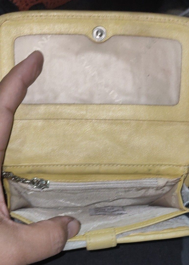 Banabana Yellow Wallet (Category: Wallets & Card holders) located in Los Banos. Submitted by tritrollse.04 (Listing ID 1426487665, Image 3). Description: Yellow Banabana wallet with a flap closure. Features a stitched pattern on the exterior. Includes multiple card slots, a clear ID window, and a zippered compartment. The wallet has a tassel detail and a metal logo. The interior is a lighter shade of yellow..