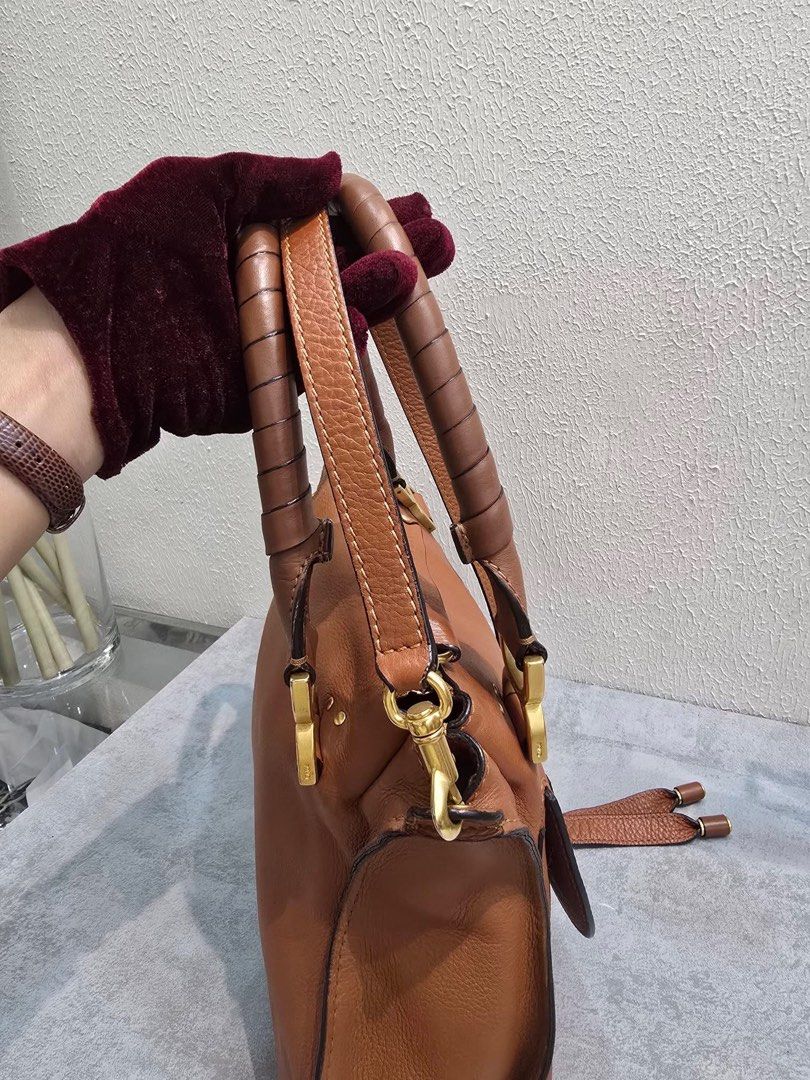 Chloe Marcie Leather Handbag (Category: Luxury Bags & Wallets) located in Davao. Submitted by jackie2276 (Listing ID 1426443480, Image 3). Description: Chloe Marcie handbag features a brown leather exterior with a top handle and a detachable shoulder strap. It has a zip closure and a fabric-lined interior with a small pocket. The bag includes gold-tone hardware and the Chloe logo is visible inside. Made in Italy..