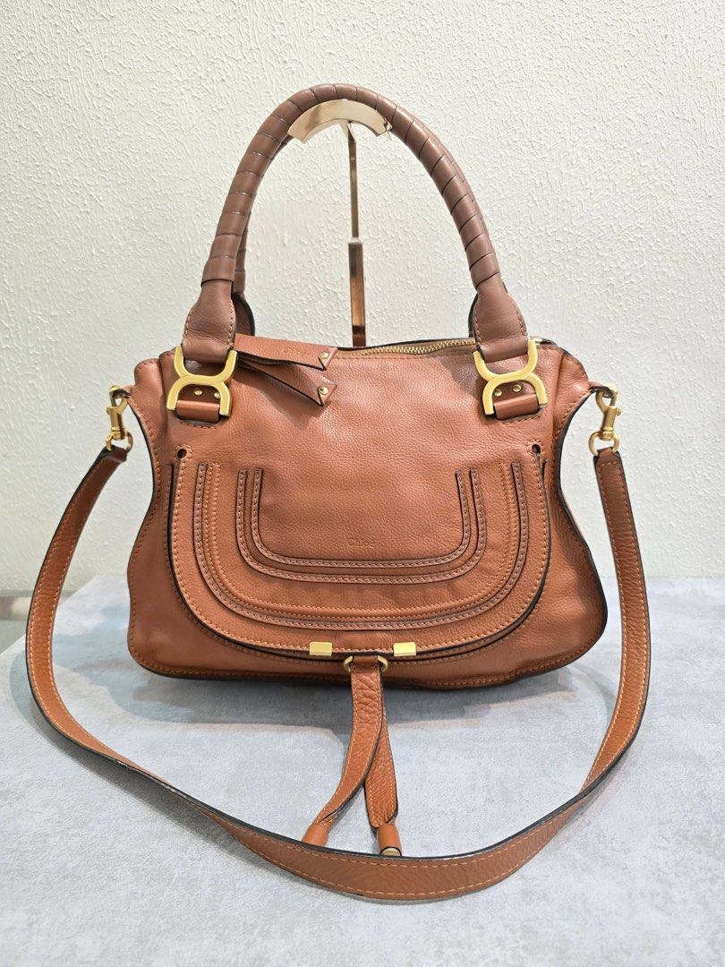Chloe Marcie Leather Handbag (Category: Luxury Bags & Wallets) located in Davao. Submitted by jackie2276 (Listing ID 1426443480, Image 1). Description: Chloe Marcie handbag features a brown leather exterior with a top handle and a detachable shoulder strap. It has a zip closure and a fabric-lined interior with a small pocket. The bag includes gold-tone hardware and the Chloe logo is visible inside. Made in Italy..