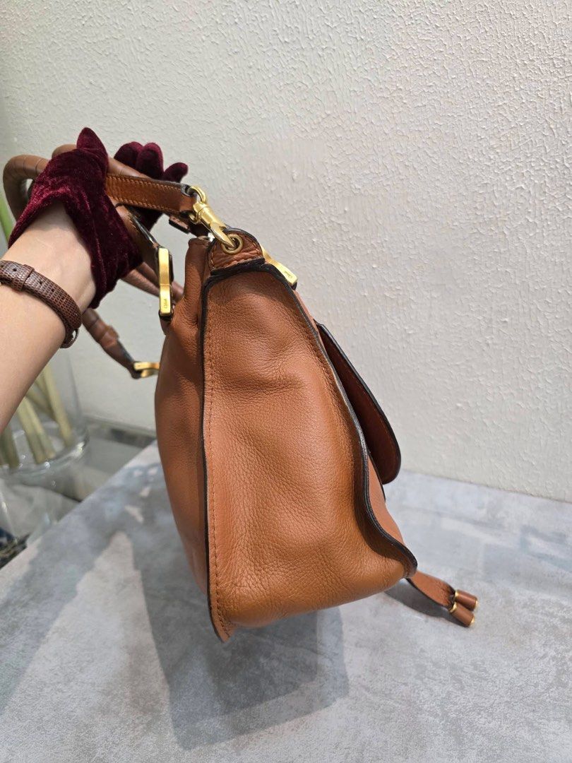 Chloe Marcie Leather Handbag (Category: Luxury Bags & Wallets) located in Davao. Submitted by jackie2276 (Listing ID 1426443480, Image 2). Description: Chloe Marcie handbag features a brown leather exterior with a top handle and a detachable shoulder strap. It has a zip closure and a fabric-lined interior with a small pocket. The bag includes gold-tone hardware and the Chloe logo is visible inside. Made in Italy..