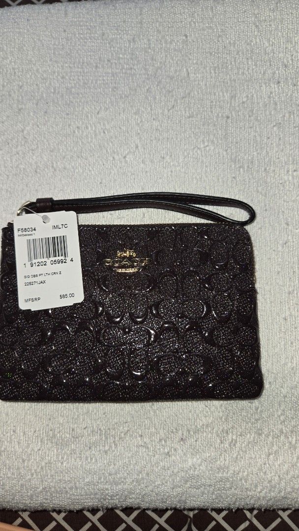 Coach Signature Wristlet (Category: Luxury Bags & Wallets) located in Quezon City. Submitted by dymc25 (Listing ID 1426414233, Image 1). Description: Dimensions: Typically measures approximately 6 1/4" (L) x 4" (H). Features: Zipper closure with gold-tone hardware. Attached wrist strap for convenient carrying. two Interior card slot Fabric lining. .