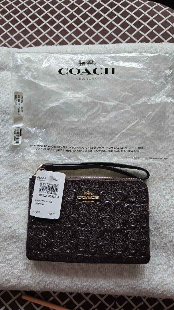 Coach Signature Wristlet (Category: Luxury Bags & Wallets) located in Quezon City. Submitted by dymc25 (Listing ID 1426414233, Image 2). Description: Dimensions: Typically measures approximately 6 1/4" (L) x 4" (H). Features: Zipper closure with gold-tone hardware. Attached wrist strap for convenient carrying. two Interior card slot Fabric lining. .