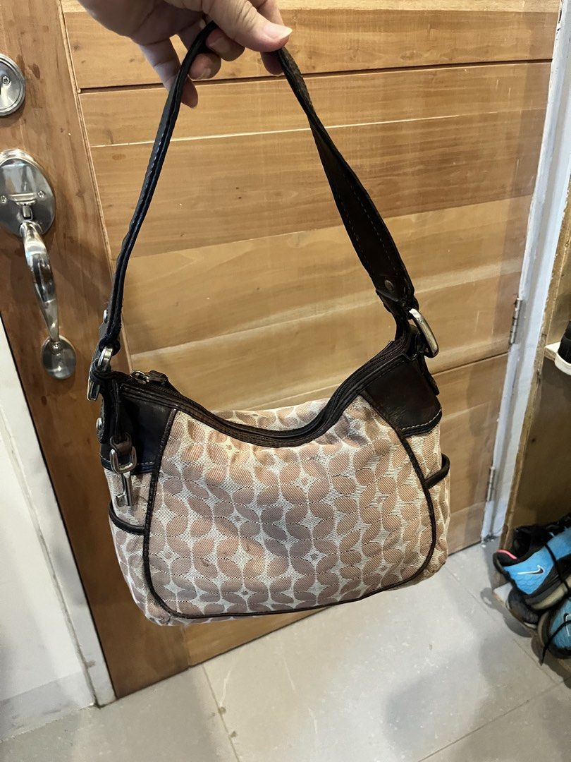 Fossil Shoulder Bag (Category: Shoulder Bags) located in Cebu City. Submitted by nbetcuban007trendyfinds (Listing ID 1426430128, Image 1). Description: Fossil shoulder bag with a floral pattern. Features a brown leather strap and trim. Includes a zippered main compartment and side pockets. The interior has a Fossil brand tag. The bag has metal feet on the bottom. .