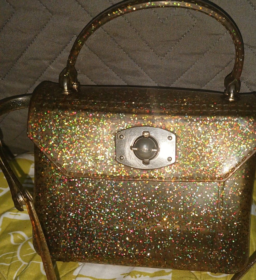 Furla Glitter Handbag (Category: Luxury Bags & Wallets) located in Rizal. Submitted by judithtillo19 (Listing ID 1426552174, Image 3). Description: Furla handbag features a glittery design with a top handle and a detachable shoulder strap. It has a rectangular shape with a clasp closure. The bag is made in Italy. The bag has a metallic silver clasp..