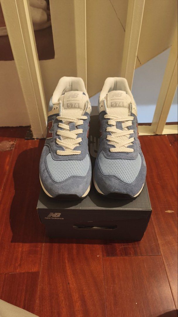 New Balance 574 Blue Sneakers (Category: Sneakers) located in Taguig. Submitted by declutterme12 (Listing ID 1426586865, Image 1). Description: Brandnew po Selling Below Market Price Size 9 New Balance 574 sneakers in blue. Features a mesh and suede upper with a classic design. The shoes have a white tongue and laces, with a maroon "N" logo on the side. The box is included. Size 9..
