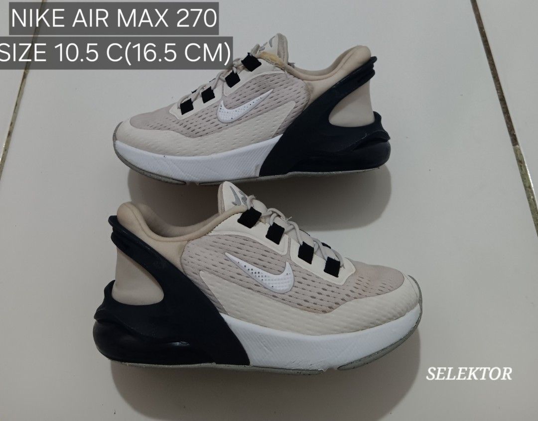 Nike Air Max 270 - Size 10.5C (Category: Babies & Kids Fashion) located in Dauis. Submitted by udenglegaspi (Listing ID 1426504016, Image 1). Description: Nike Air Max 270 sneakers in a beige and black colorway. Features a white midsole and a grey outsole. Size is 10.5C (16.5 cm). The shoes have a mesh upper with the Nike swoosh logo on the side. The shoes have black laces and a black heel counter..
