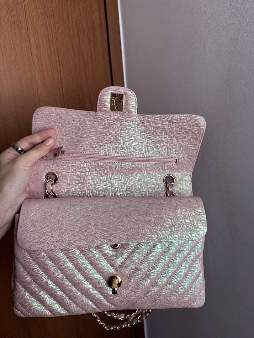 Rare Chanel Chevron Medium Flap Bag - Pink Iridescent (Category: Luxury Bags & Wallets) located in Pasig City. Submitted by gluxerare (Listing ID 1426445235, Image 3). Description: Super pretty bag ! 😍What you see is what you get! Chanel flap bag features a unique iridescent pink color with a chevron pattern. It has a gold chain strap and a classic CC turn-lock closure. The interior includes a main compartment and a zippered pocket. The bag's de