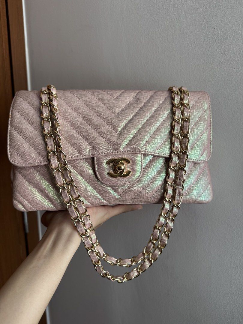 Rare Chanel Chevron Medium Flap Bag - Pink Iridescent (Category: Luxury Bags & Wallets) located in Pasig City. Submitted by gluxerare (Listing ID 1426445235, Image 1). Description: Super pretty bag ! 😍What you see is what you get! Chanel flap bag features a unique iridescent pink color with a chevron pattern. It has a gold chain strap and a classic CC turn-lock closure. The interior includes a main compartment and a zippered pocket. The bag's de