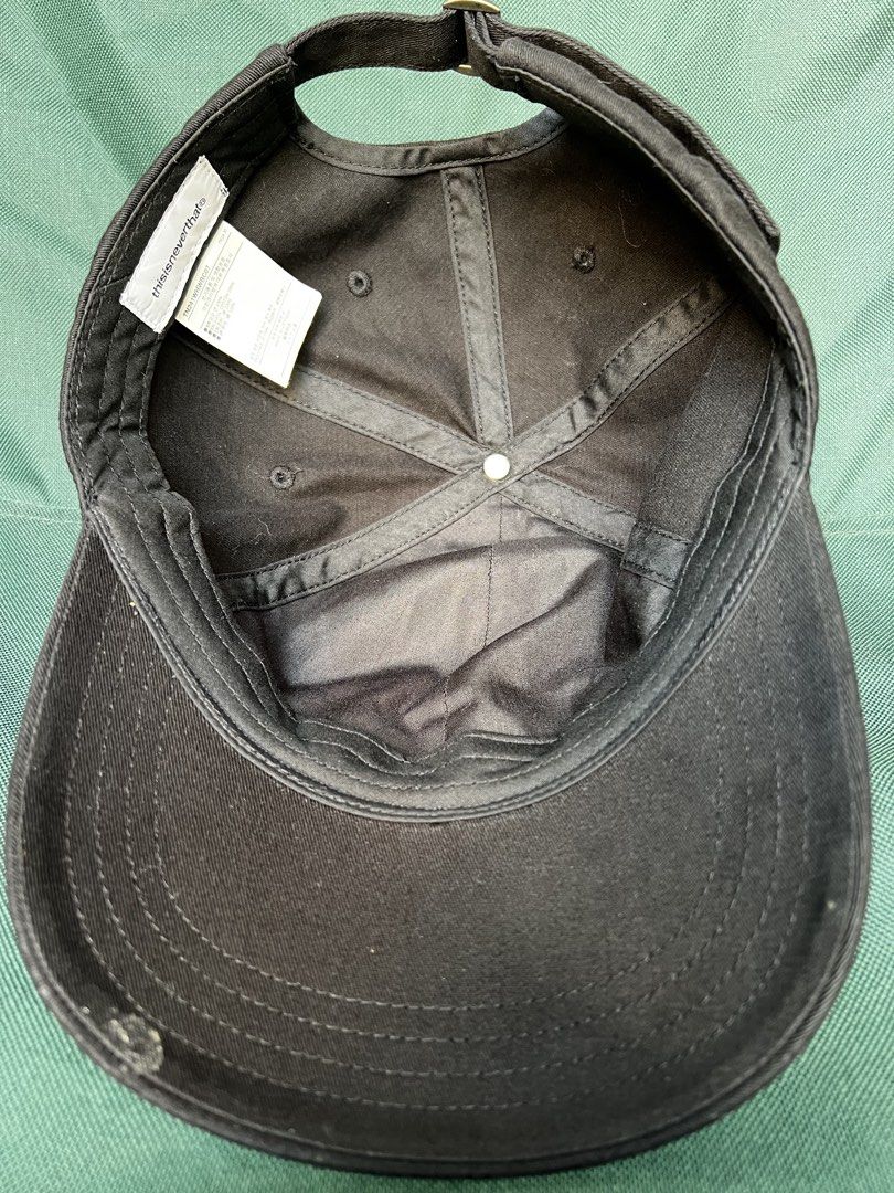 thisisneverthat Cap (Category: Caps & Hats) located in San Francisco. Submitted by ranjugals (Listing ID 1426454818, Image 3). Description: Black cap from thisisneverthat. Features the brand's logo embroidered in red on the front. Adjustable strap at the back with the brand's logo. The tag indicates the cap is made in Vietnam..