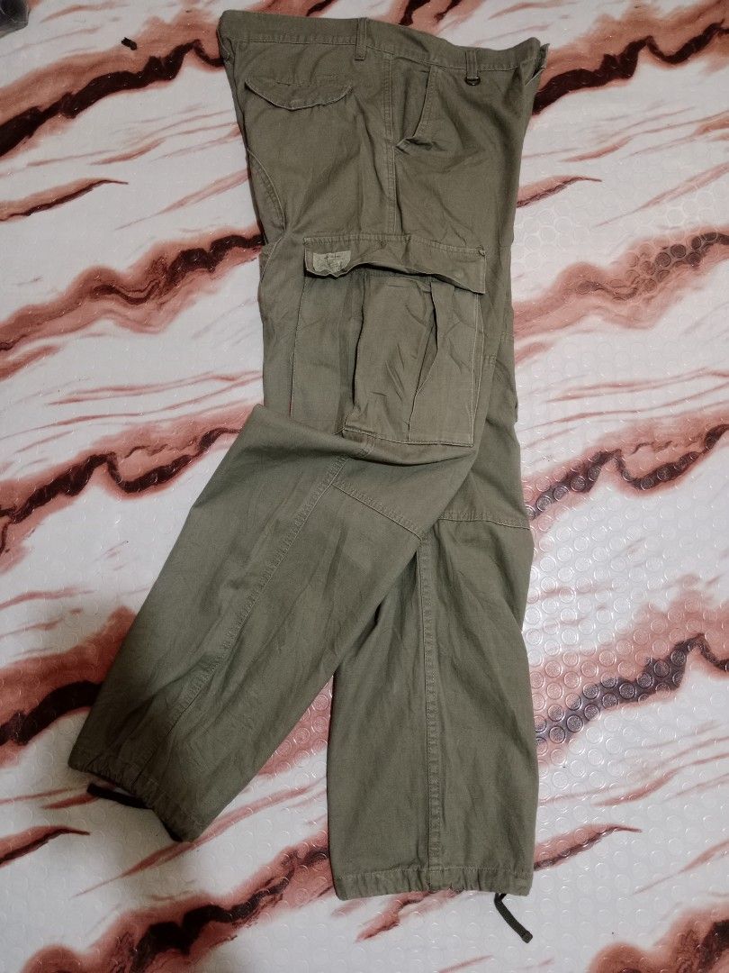 Wassup Cargo Pants - Olive Green - Size L (Category: Jeans) located in Roxas, Palawan. Submitted by cabreramed14075 (Listing ID 1426455453, Image 3). Description: Olive green cargo pants from Wassup. Features multiple pockets and adjustable drawstrings at the ankles. The pants have a button closure and a metal D-ring detail. Size L. Waist measures approximately 16 inches across. Inseam is approximately 30 inches. The pants appear to be made of a 
