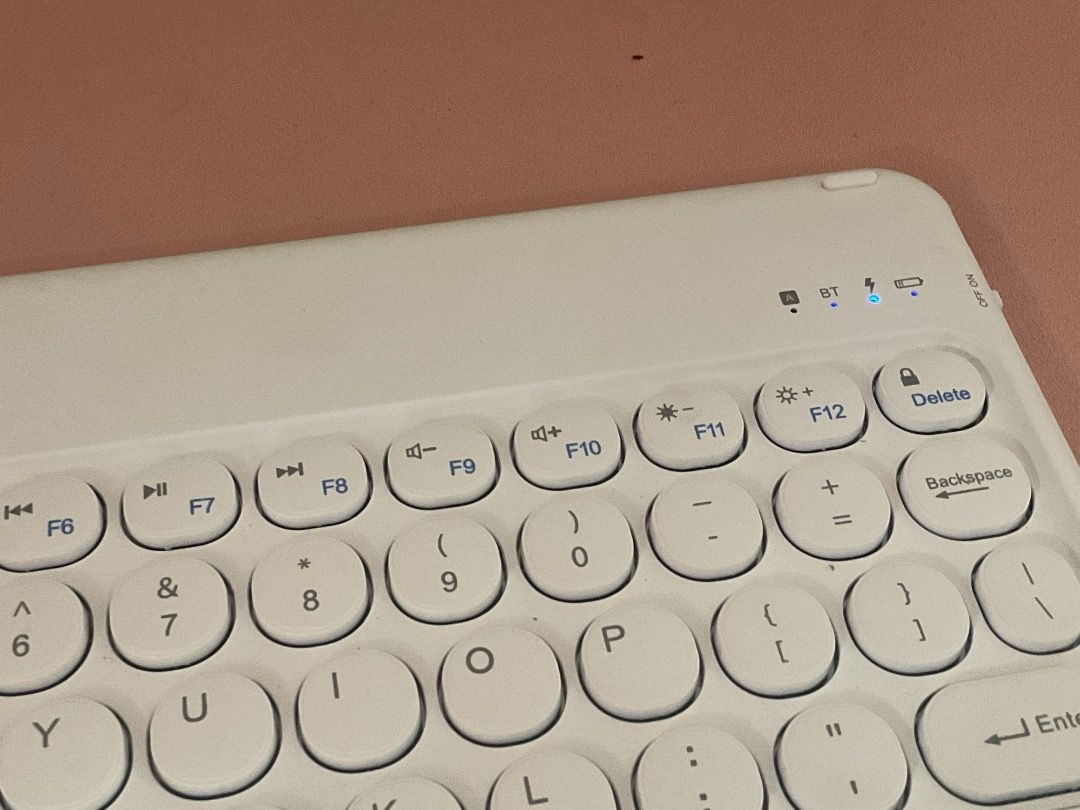 Wireless Bluetooth Keyboard (Category: Computer Keyboard) located in Manila. Submitted by rinangelic36923 (Listing ID 1426462197, Image 3). Description: White wireless Bluetooth keyboard. Features a full QWERTY layout with function keys and a dedicated delete key. Includes a charging port. It is compact and portable, suitable for use with tablets or other devices..