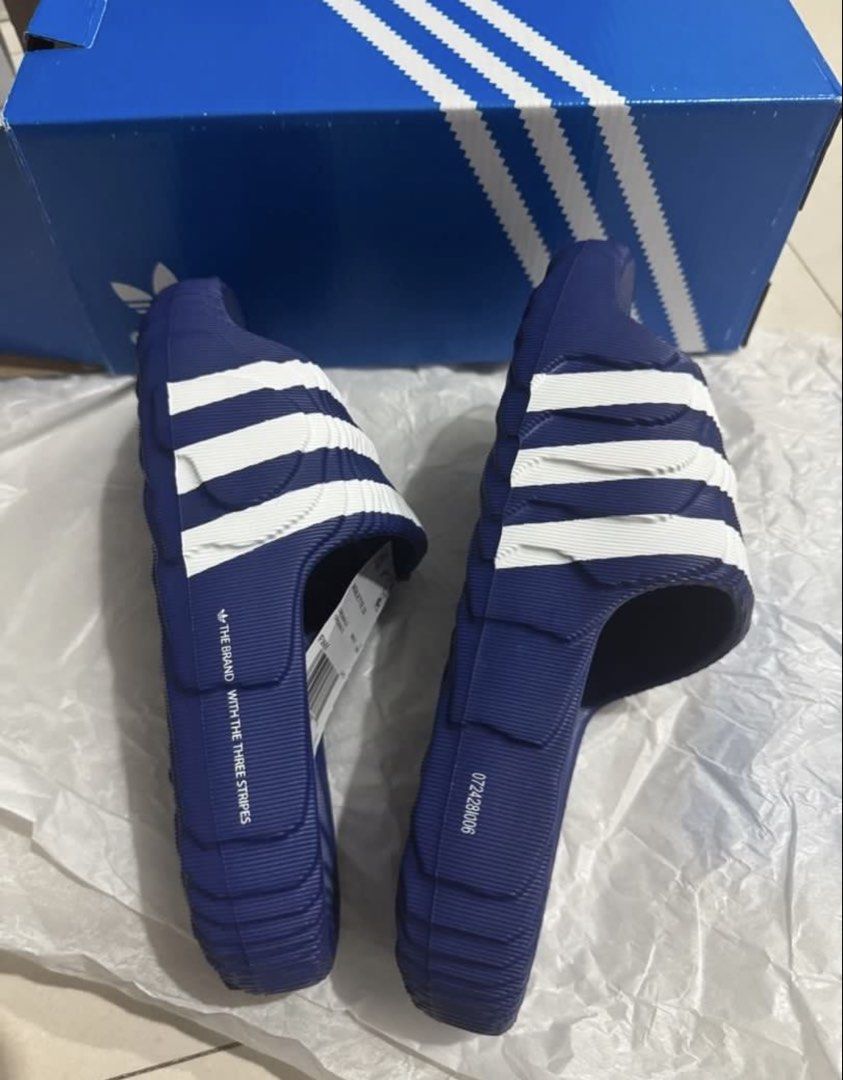 Adidas Adilette 22 Slides - Blue (Category: Slippers & Slides) located in Manila. Submitted by bornthisway22 (Listing ID 1426736062, Image 2). Description: Adidas Adilette 22 slides in blue with white stripes. Features the Adidas logo on the footbed. The slides come with the original box and tags. The size is visible on the tag. The slides have a textured design on the footbed and sole for added grip and comfort..