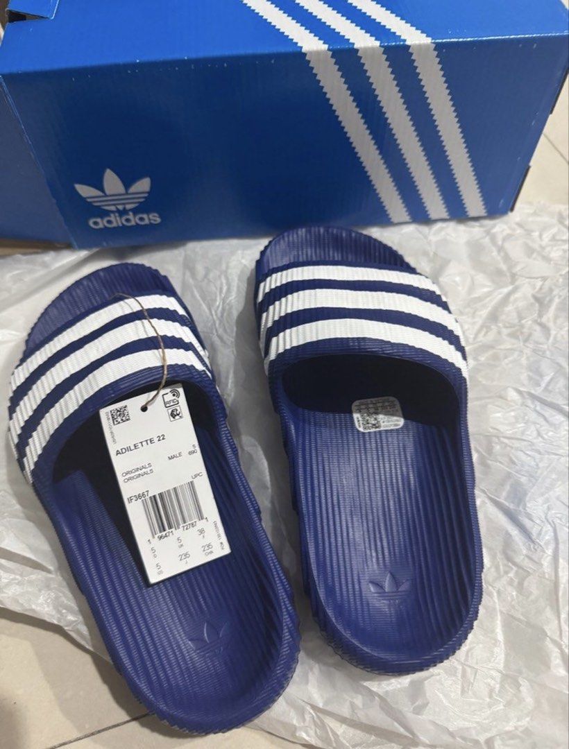 Adidas Adilette 22 Slides - Blue (Category: Slippers & Slides) located in Manila. Submitted by bornthisway22 (Listing ID 1426736062, Image 3). Description: Adidas Adilette 22 slides in blue with white stripes. Features the Adidas logo on the footbed. The slides come with the original box and tags. The size is visible on the tag. The slides have a textured design on the footbed and sole for added grip and comfort..