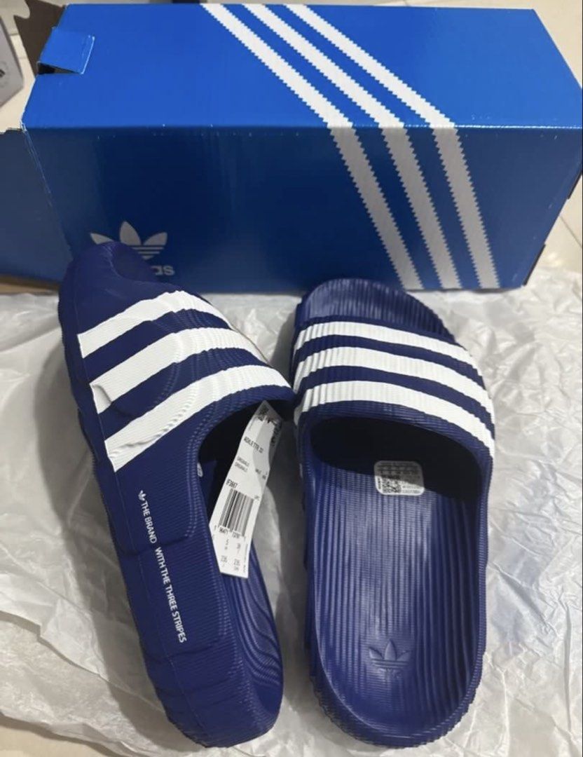 Adidas Adilette 22 Slides - Blue (Category: Slippers & Slides) located in Manila. Submitted by bornthisway22 (Listing ID 1426736062, Image 1). Description: Adidas Adilette 22 slides in blue with white stripes. Features the Adidas logo on the footbed. The slides come with the original box and tags. The size is visible on the tag. The slides have a textured design on the footbed and sole for added grip and comfort..