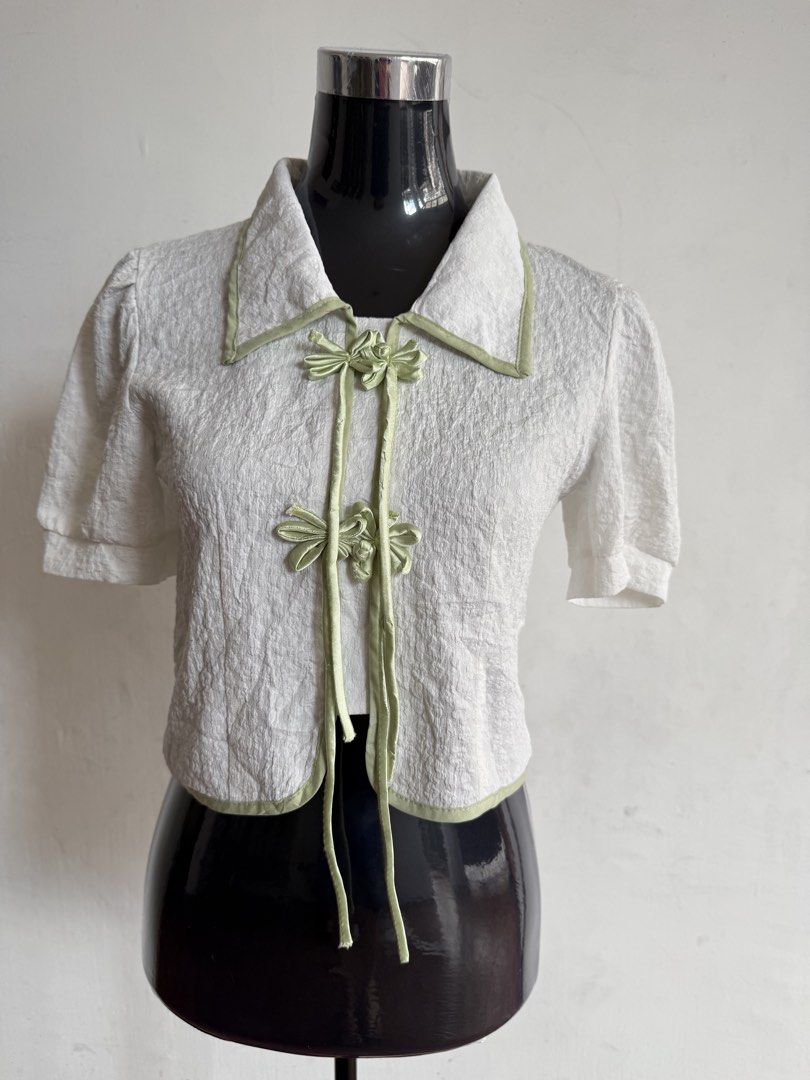 ASEAN Inspired Blouse (White & Sage Green) (Category: Sleeveless) located in Quezon City. Submitted by kweenbii (Listing ID 1426663239, Image 1). Description: Elegant ASEAN / Filipiniana inspired blouse with sage green accents 🌿 Perfect for government employees and professionals who wear Filipiniana / ASEAN attire every Monday. Classic design with traditional frog button details and a modern minimalist look. ✨ Details: • Textured white fabric • 