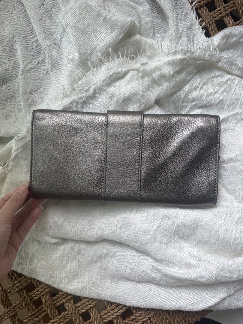 Auth. Michael Kors Metallic Silver Grey Buckle Clutch (Category: Clutches) located in Taguig. Submitted by sakuraaaaa____ (Listing ID 1426595657, Image 2). Description: Authentic Michael Kors Leather clutch with silver hardware buckle. Fliptop magnetic snap closure. Interior has the signature michael by Michael kors grey signature fabric lining. 6 credit card slots and a slip pocket. No issues! Used a few times.