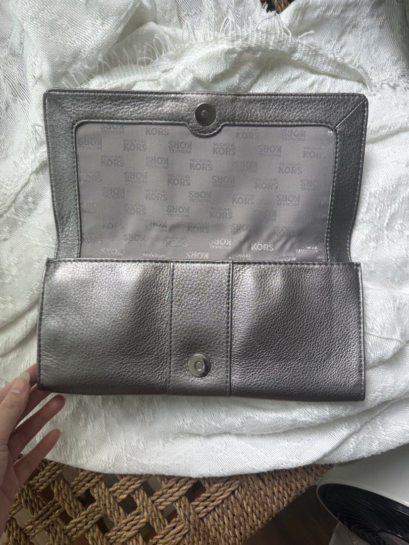 Auth. Michael Kors Metallic Silver Grey Buckle Clutch (Category: Clutches) located in Taguig. Submitted by sakuraaaaa____ (Listing ID 1426595657, Image 3). Description: Authentic Michael Kors Leather clutch with silver hardware buckle. Fliptop magnetic snap closure. Interior has the signature michael by Michael kors grey signature fabric lining. 6 credit card slots and a slip pocket. No issues! Used a few times.