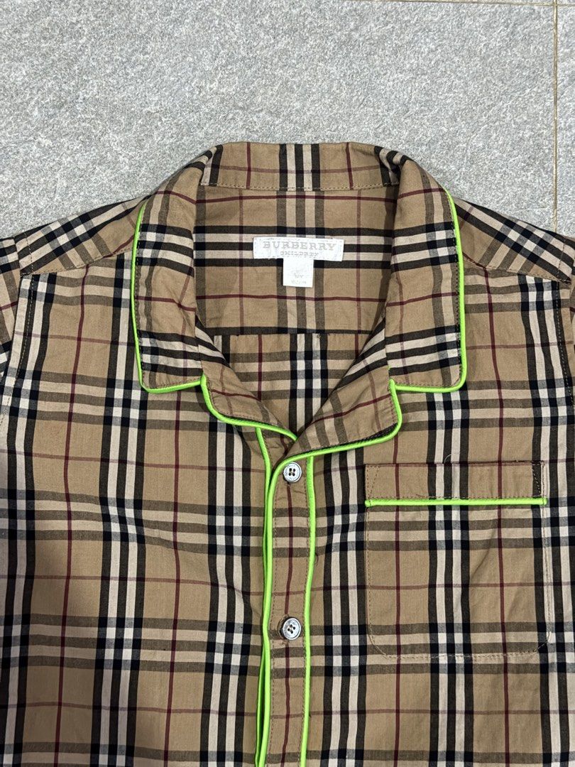 Authentic Burberry Checkered Shirt 12YO on tag (152cm) (Category: Babies & Kids Fashion) located in Cebu City. Submitted by llben07 (Listing ID 1426650485, Image 3). Description: Burberry kids shirt in a classic checkered pattern. Features a collared neckline, short sleeves, and neon green trim. The shirt has button closures down the front. Made from 100% cotton. Size is 12Y. Made in China..